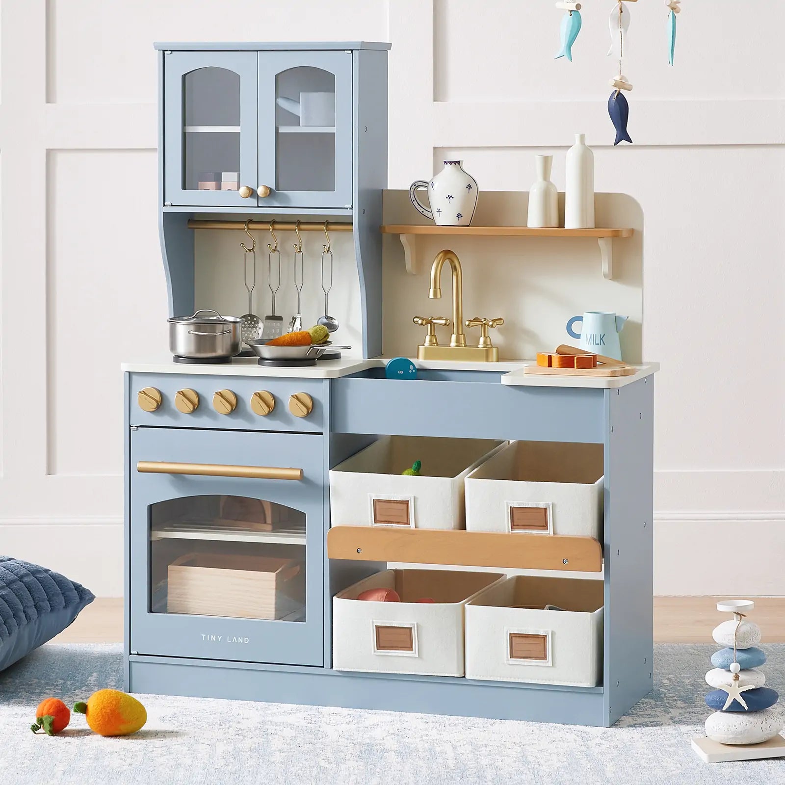 Tiny Land blue wooden play kitchen with sink, stove, gold faucet, hanging utensils, cookware, and organized storage bins