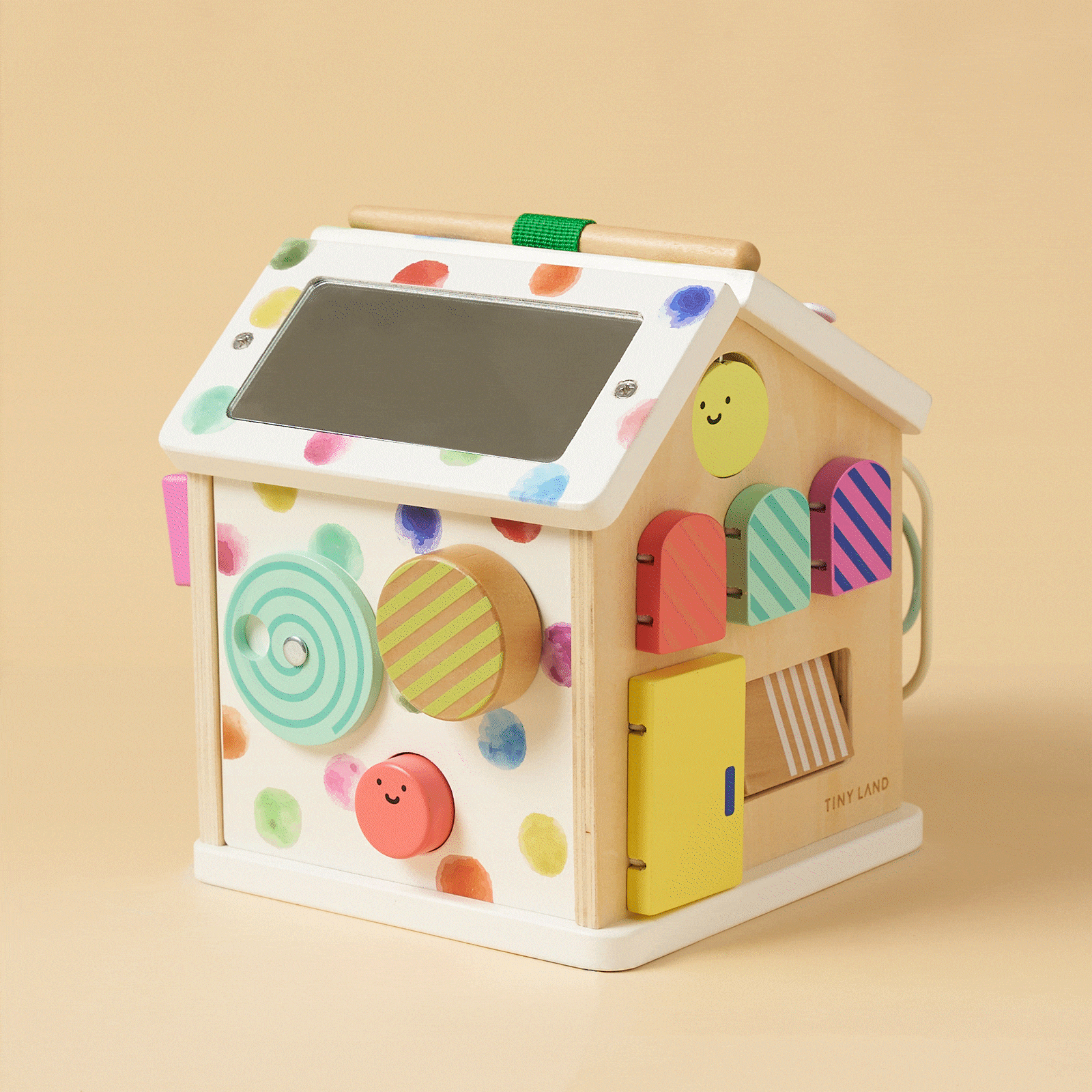 The Tiny Land® Cottage Activity Cube - Rainbow by Tiny Land is a colorful, house-shaped Montessori toy with painted dots, smiley faces, a mirror, gears, spinning discs, doors, and sensory features for fun developmental play.