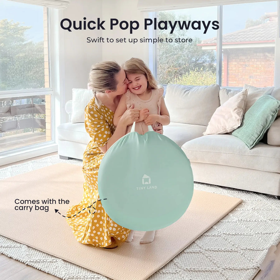 A smiling woman hugs a joyful girl with the Tiny Land® Adventure Play Tunnel - Green in their cozy living room. The bright play tunnel brings fun and adventure to their day. Text reads Quick Pop Playways.|green
