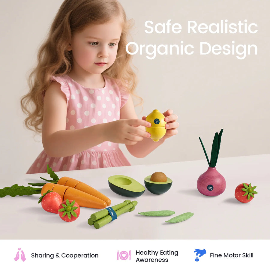 A young child in a pink polka-dot dress plays with the Tiny Land® Organic Fruit & Veggie Pack—realistic, colorful wooden toy fruits and vegetables—on a table. Text reads Safe Realistic Organic Design. Icons indicate sharing, healthy eating, and fine motor skills. Brand: Tiny Land.