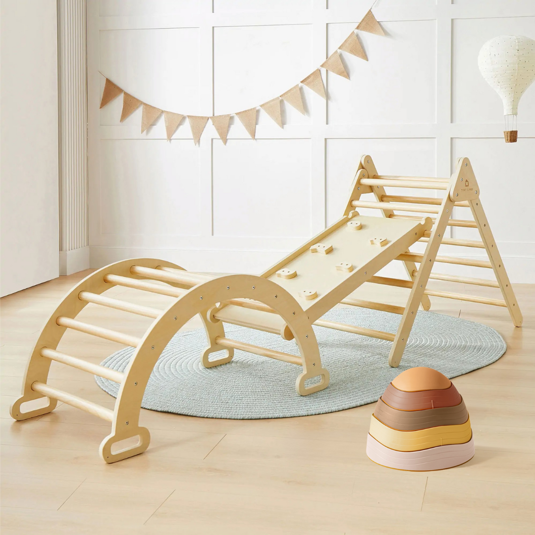 The Tiny Land Active Adventure Playset—Natural Wood Climbing Set with climbing arch, ramp, and triangle pairs with Sunset Hues Stepping Stones on a light blue rug, creating a bright, cozy indoor playground for balance play.