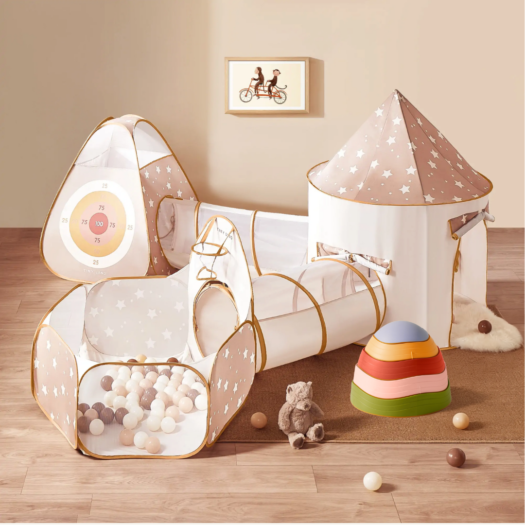 The Tiny Land Discovery & Balance Playset is a beige 5-in-1 indoor set with star patterns, castle, crawl tunnel, ball pit with pastel balls, plush teddy bear, rainbow stacking toy, vintage color stepping stones, and playful kids wall art.
