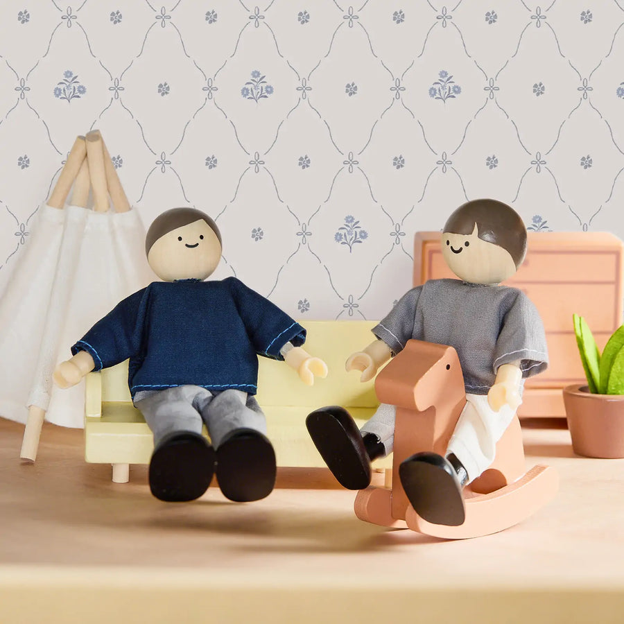 Two Tiny Land® Wooden Dollhouse Dolls from Tiny Land relax in a miniature living room with a yellow sofa, peach rocking horse, patterned wallpaper, small plant, and white teepee.