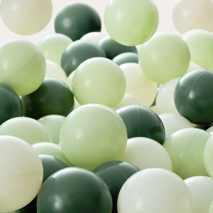 A collection of Tiny Land® Ocean Ball - 200 pcs with Varied Colors from Tiny Land is shown in green and white tones, overlapping against a plain light background. These non-toxic play balls appear to be floating or falling.|Green