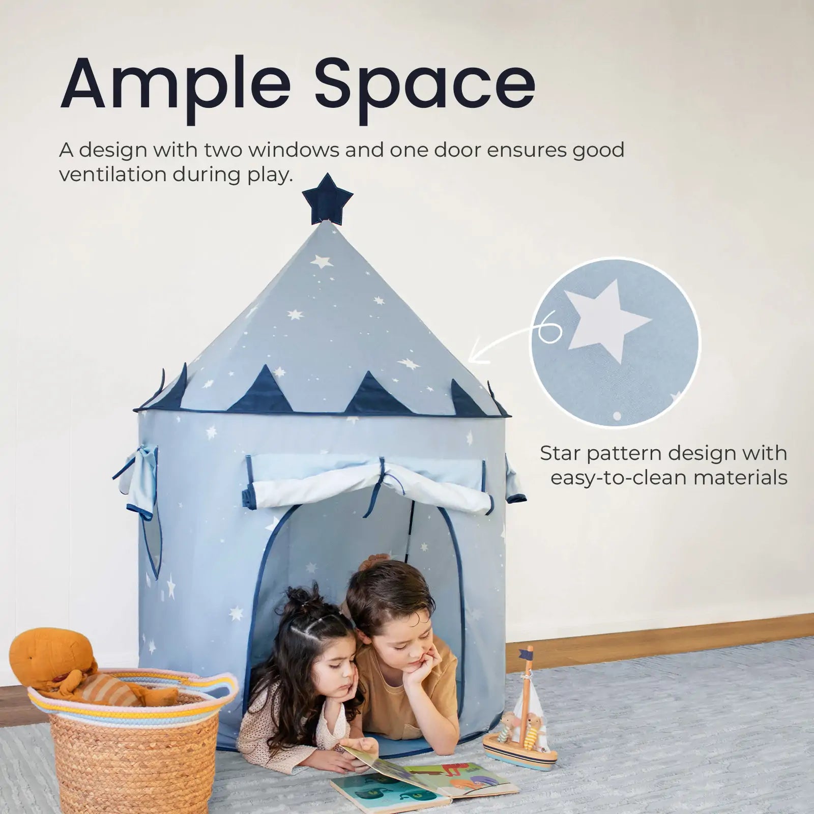 Two children read in front of the Tiny Land® Kids Tent – Starry Blue Indoor Tent for Toddlers, featuring star patterns, two windows, and a door. The spacious tent adds a cozy touch to the room alongside toys and a basket.
