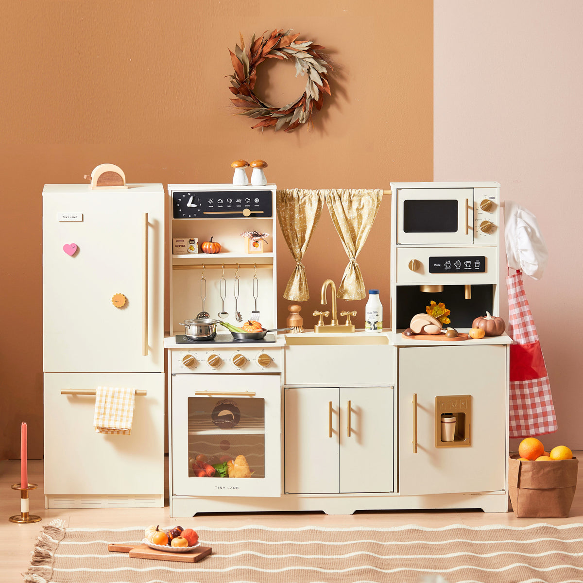 Introducing the Tiny Land All-in-One Family Feast Gift Set: Luxury Kitchen & Fridge & Organic Food Collection—a beautifully crafted children’s wooden play kitchen in elegant cream and wood tones. This deluxe set features a fridge, oven, sink, stove, and microwave, complete with toy organic food and utensils for immersive pretend play. Charming touches like a decorative wreath and gold curtains above the kitchen add to the imaginative experience, making it perfect for inspiring little chefs.