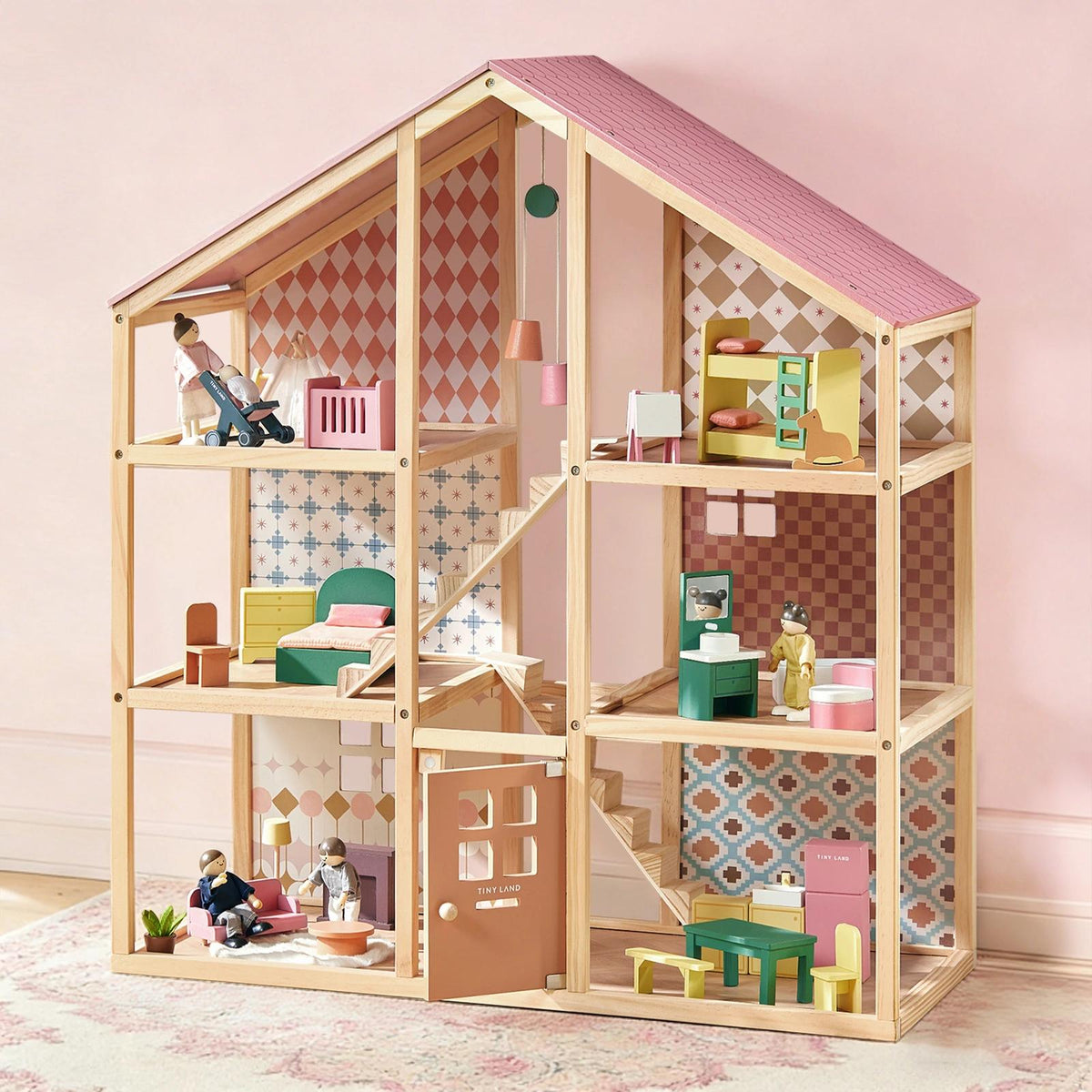 The Tiny Land® Sweetwood Pegasus Dollhouse & Wooden Dollhouse Dolls by Tiny Land features vibrant, multi-room designs, miniature furniture, and poseable dolls—perfectly displayed against a light pink background wall.