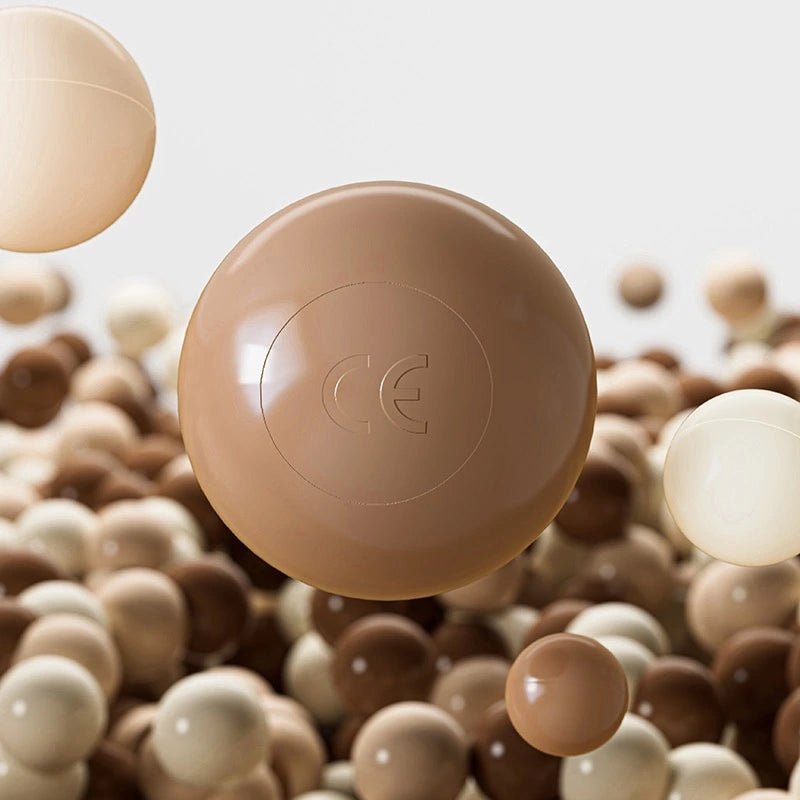 A cluster of smooth, shiny Tiny Land® Ocean Balls in varied colors float together, with one central ball featuring an embossed CE mark. The softly blurred background highlights these 200 high-quality balls from Tiny Land.