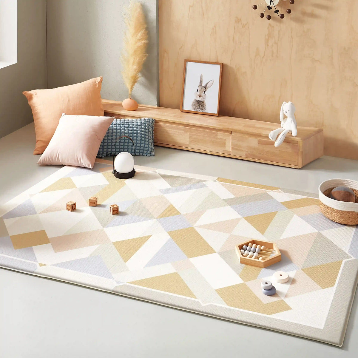 A cozy, modern nursery with the Tiny Land® Double-Sided Baby Playmat Urban Zoo Adventure by Tiny Land, a wooden bench with drawers, pastel pillows, soft toys, and a framed rabbit picture. Neutral tones and the waterproof playmat create a calm space.