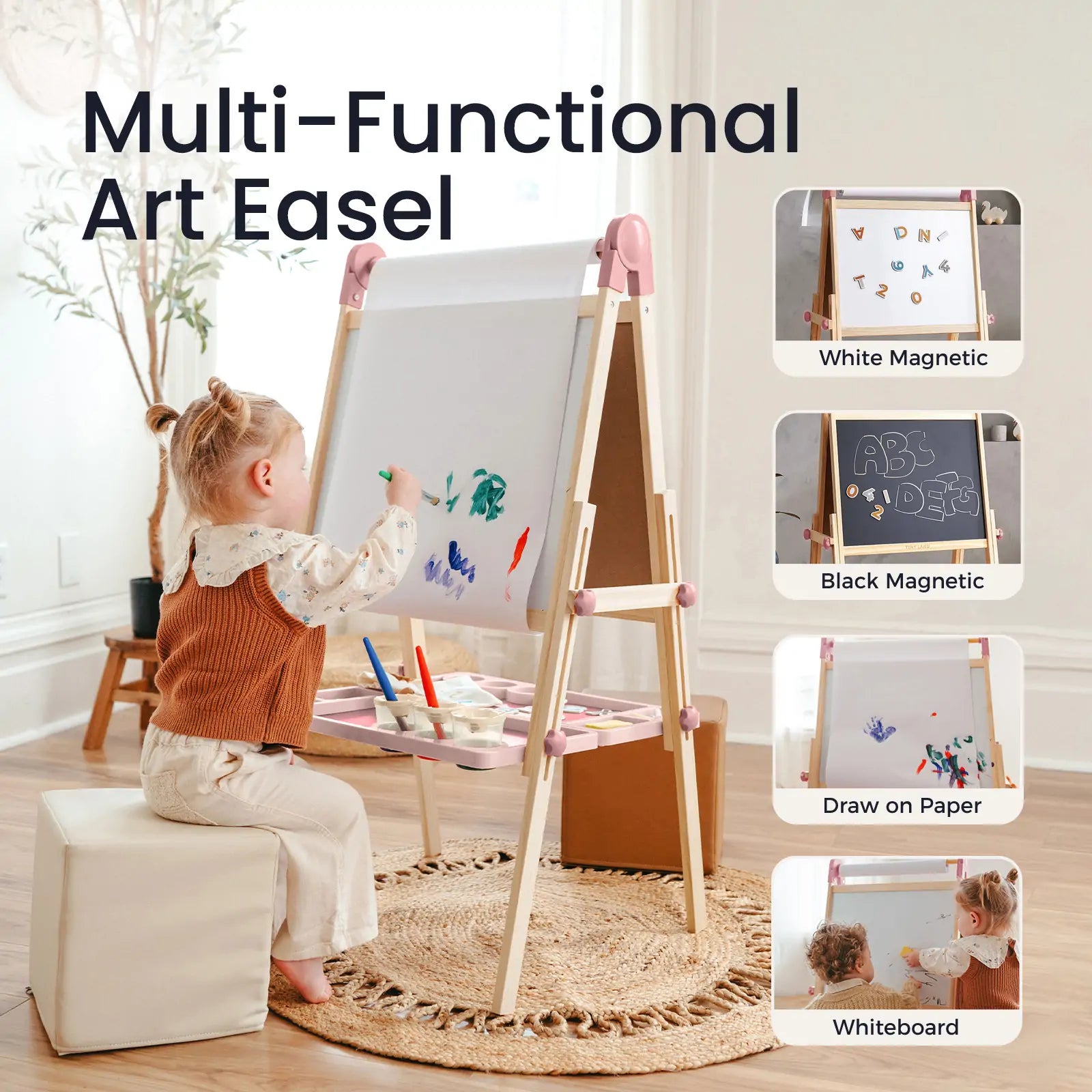 A young child sits on a cushioned stool, drawing with paint on the Tiny Land® Magnitales Easel for Kids - Pink. This multi-functional easel by Tiny Land features white and black magnetic boards, paper drawing, whiteboard options, and holds art supplies on its tray.