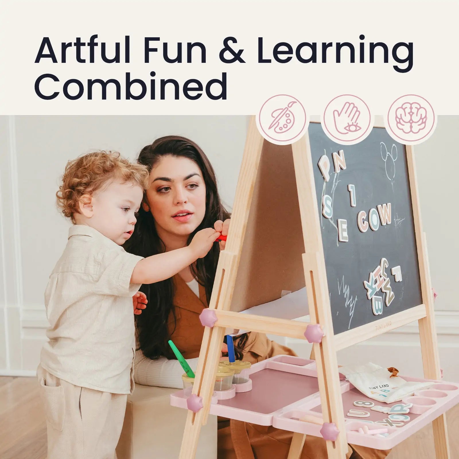 A woman and child play and learn at the Tiny Land® Magnitales Easel for Kids - Pink, a magnetic, height-adjustable easel with art supplies. “Artful Fun & Learning Combined” appears above, with icons showing creativity and cognitive skill development.