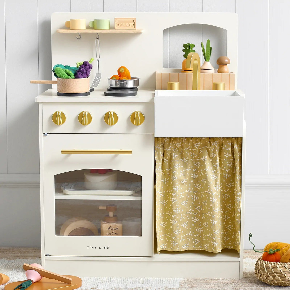 The Tiny Land® Chef’s Corner Playset – Cream Playhouse + Cream Kitchen Set by Tiny Land features a pastel stove, oven, sink, yellow floral curtain, toy food, utensils, pots, veggies, and wooden accessories—perfect for playhouse fun!|white