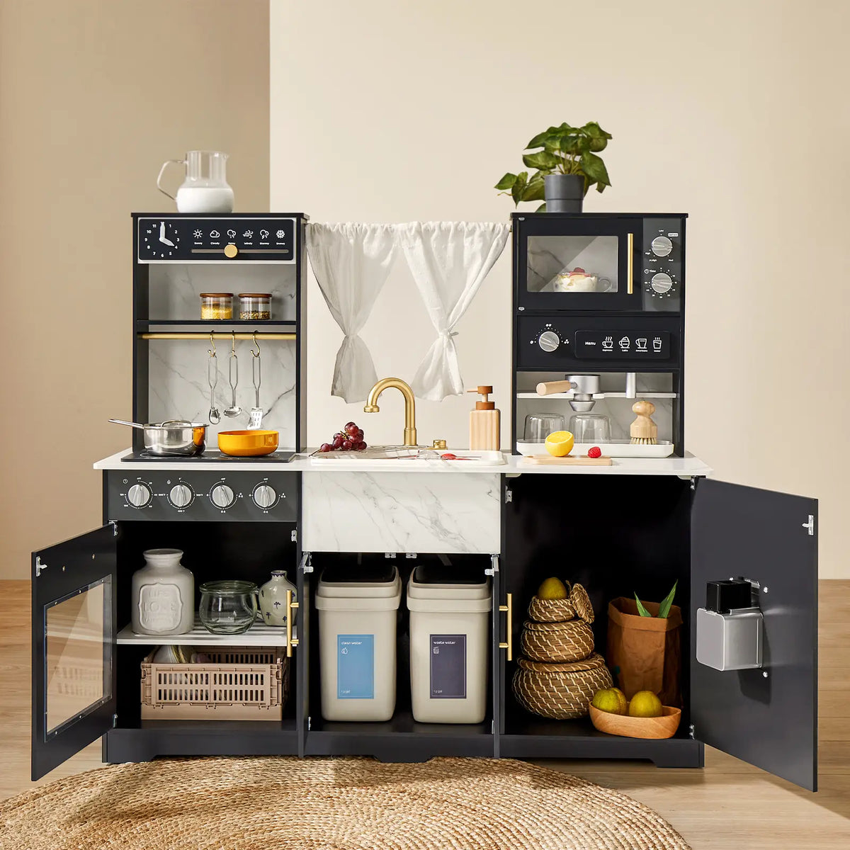 The Tiny Land® Play Kitchen with Running Water - Iconic Aqua Kitchen in Black features black cabinets, gold handles, a faux marble countertop, kitchen accessories, toy food items, and organized storage bins underneath. A small plant decorates the top.