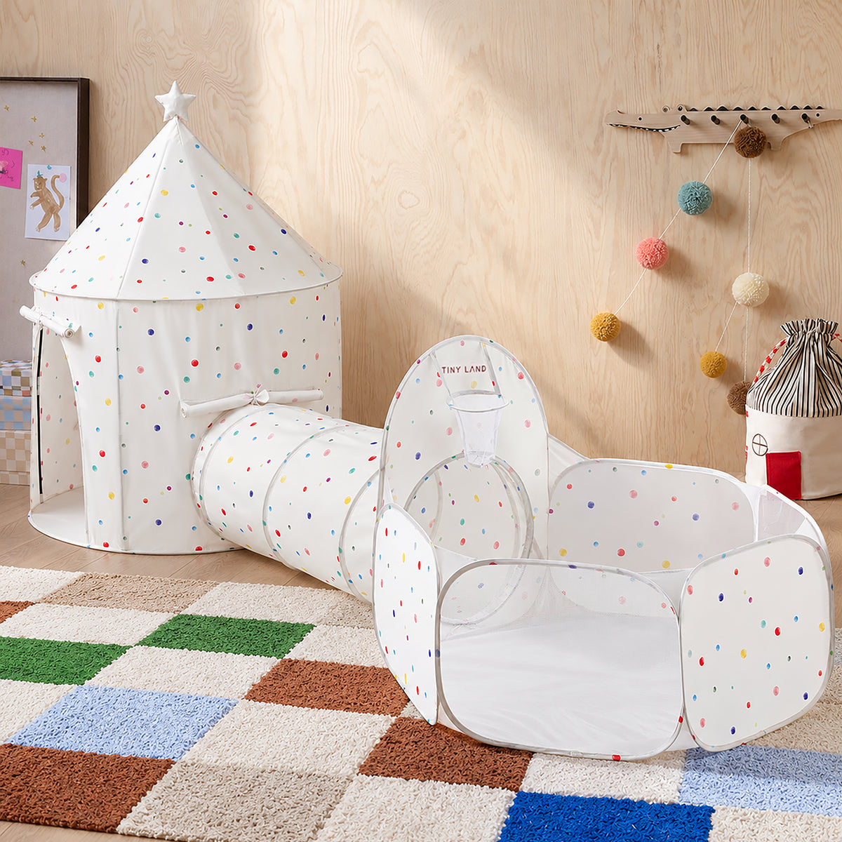 Tiny Land® Compact Adventure 3-in-1 Play Tunnel consisting of a conical tent, a play tunnel, and a ball pit with a built-in basketball hoop, all featuring white fabric with multicolored polka dots.|Colorful Dots