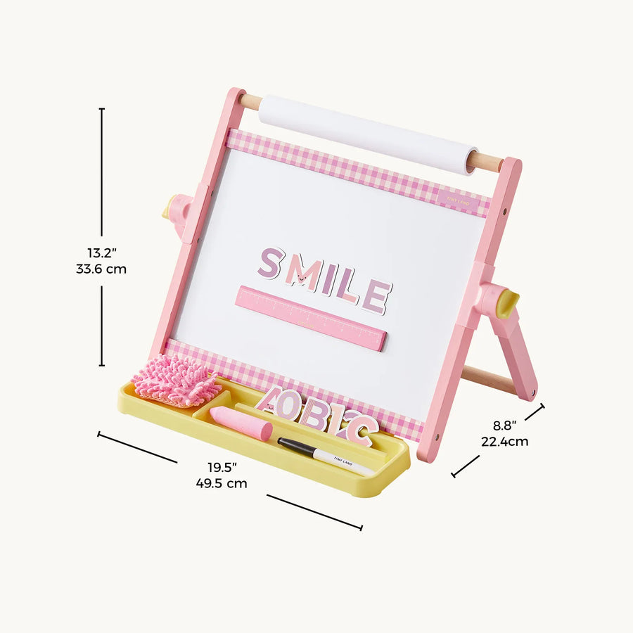 The Tiny LandĀ® Double-Sided Magnetic Tabletop Easel from Tiny Land is a pink and white adjustable kids' art station featuring a measuring tray, marker, eraser, and letter tiles spelling "SMILE." This versatile easel includes a magnetic whiteboard surface and measures 13.2" H x 8.8" D x 19.5" W.|Pink