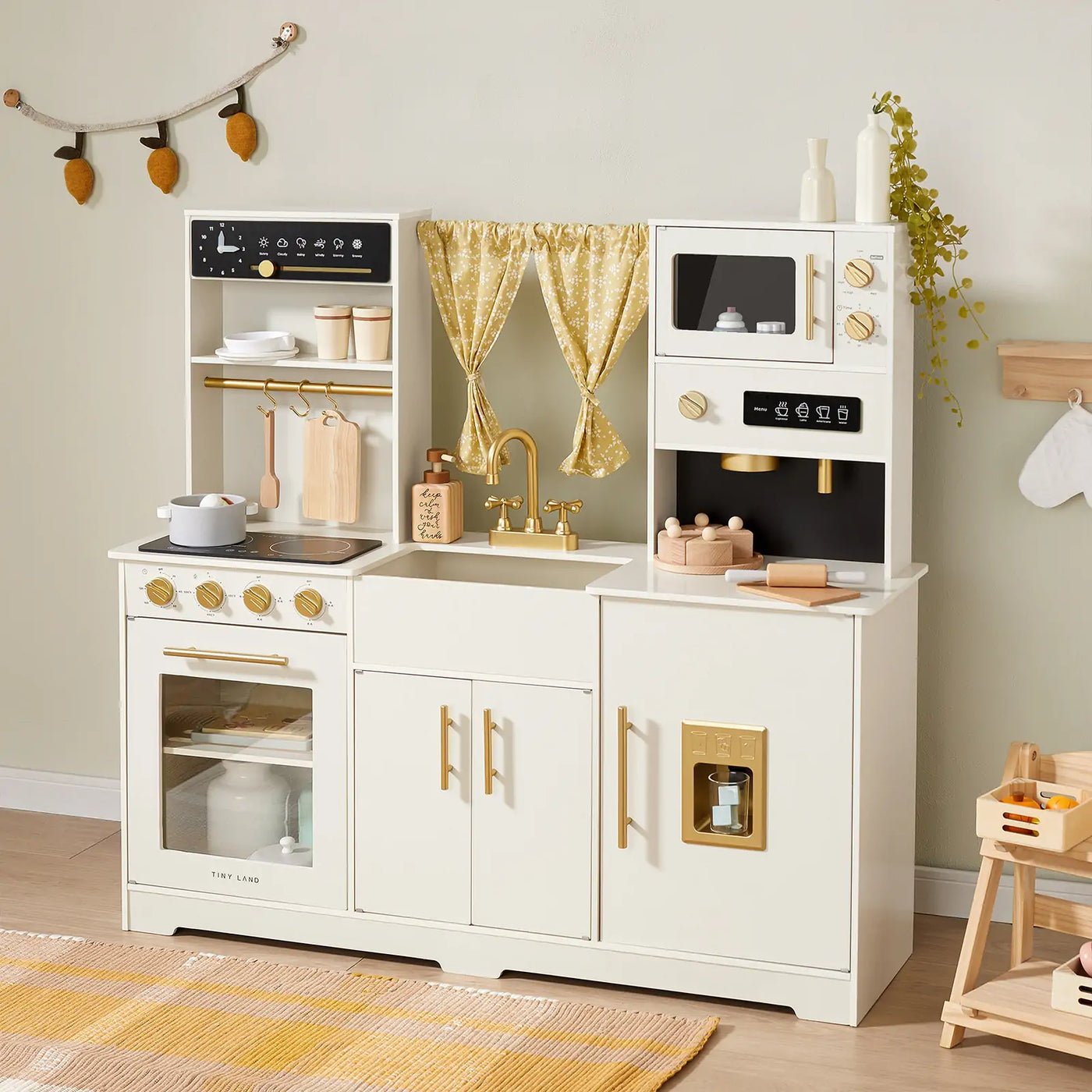 The Tiny Land® Iconic Wooden Play Kitchen – Cream Pretend Cooking Set for Kids features a stove, oven, sink, and microwave with gold accents, plus toy utensils, dishes, a pot, and curtains—perfect for imaginative play.