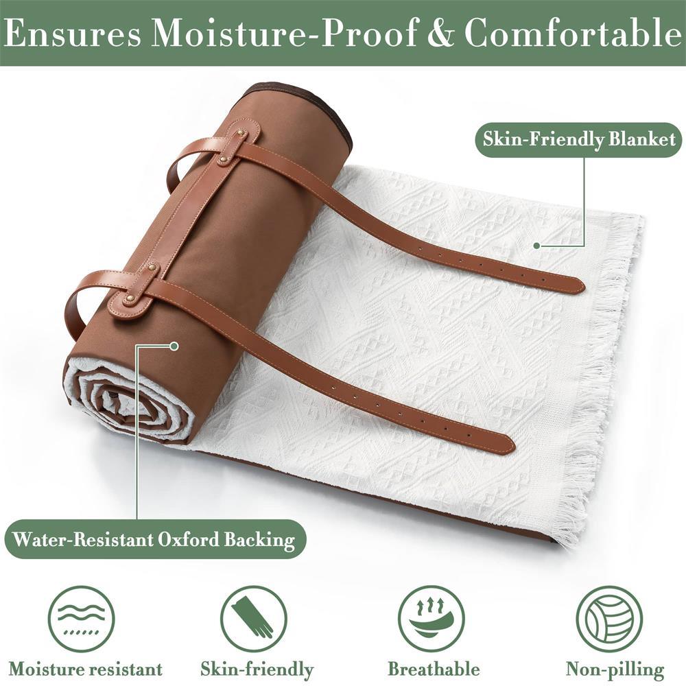 The Tiny Land® Picnic Blankets for Family by Tiny Land feature a white textured design with fringe edges, rolled up and secured by brown leather straps. Labels note its skin-friendly, breathable, moisture-resistant, and non-pilling.