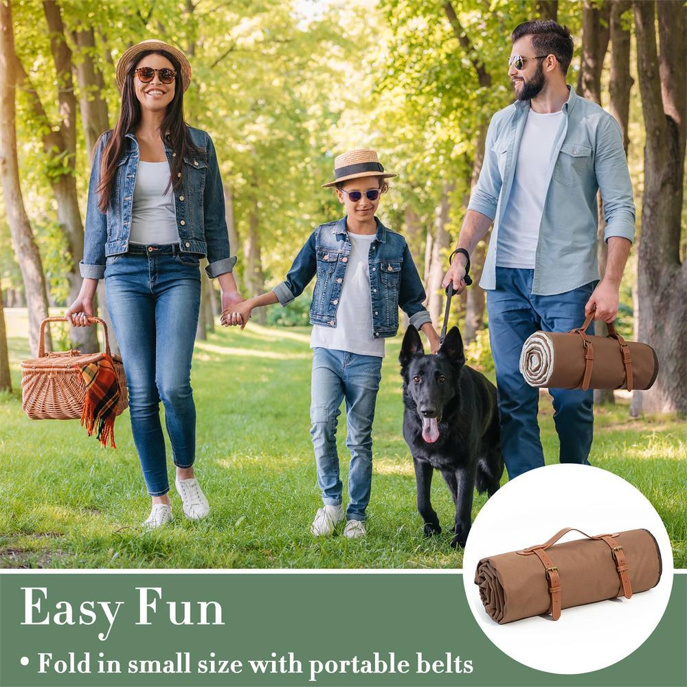 A family of three strolls in the park with their black dog, carrying a Tiny Land® Picnic Blanket and a picnic basket. They wear casual outfits and sunglasses. “Easy Fun” and Tiny Land product info appear at the bottom.