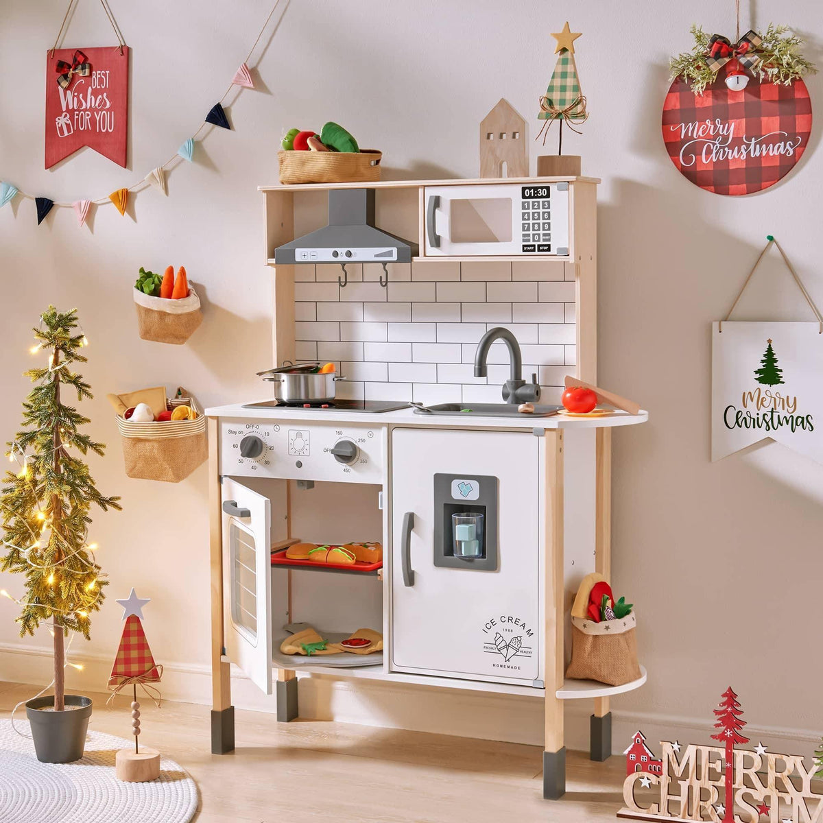 The Tiny Land® Farm-to-Table Gift Set—Light & Sound Kitchen & Market Stall is a children's pretend play kitchen with toy food, a mini Christmas tree, holiday wall signs like "Merry Christmas," and festive ornaments for the season.