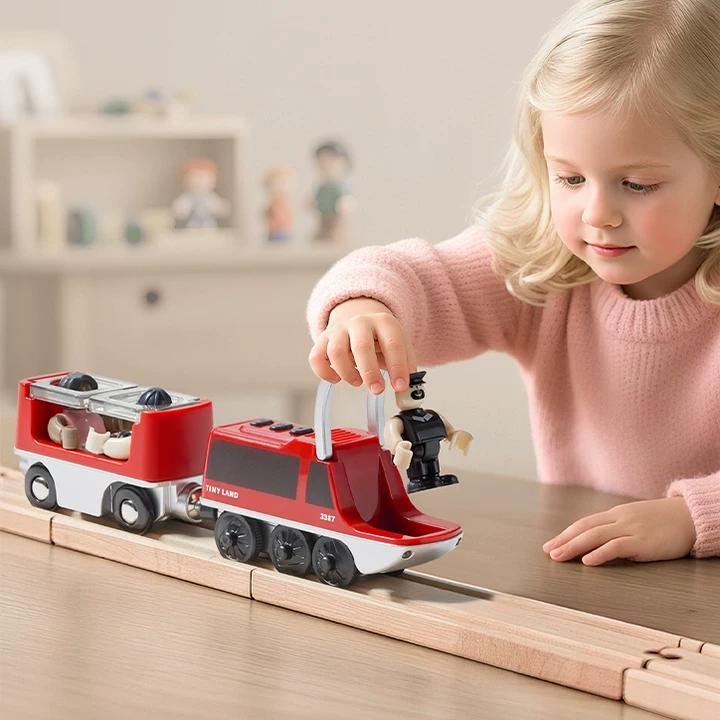 A little girl is playing an electric train set with passengers on the table with smile