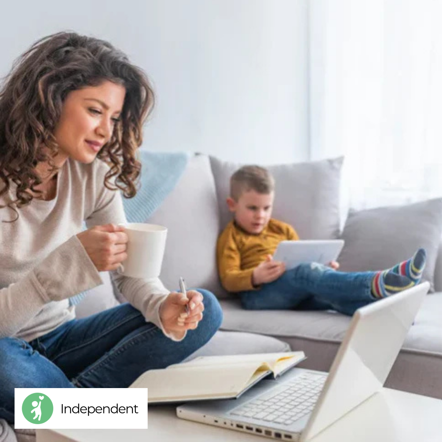 A mom is doing her work while her son is playing by himself 