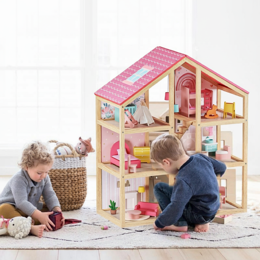 Two little boys wearing long-sleeved tops and pants are sitting on the floor playing with a pink dollhouse.