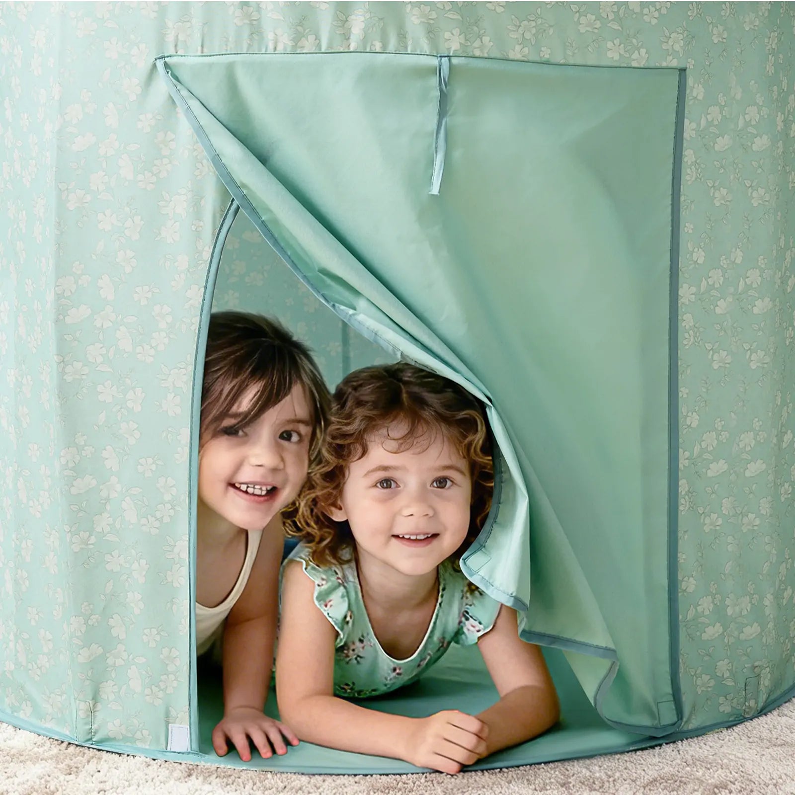 Two young children smile as they peek out from the entrance of the Tiny Land® Compact Adventure 3-in-1 Play Tunnel With no Balls - Green, set up indoors on a soft carpet, ready for adventure and imaginative play.
