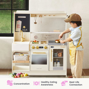 A young child wearing a hat and apron plays with the Tiny Land® BistroSwitch Kitchen & Fridge Set by Tiny Land. Toy food, kitchen utensils, and mini appliances are visible. Three icons below highlight concentration, healthy eating awareness, and real-life connection, making this kids play kitchen set perfect for imaginative pretend play.