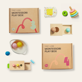 Two Tiny Land® Montessori Early Skills Baby Sets (7–12 months) from Tiny Land are labeled boxes surrounded by wooden toys—stacking rings, balls, a fabric square, and shape-sorters—designed to promote fine-motor development on a light background.
