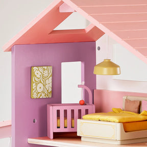 The Tiny Land® Sweetwood Cottage Dollhouse by Tiny Land features a charming bedroom with purple and pink walls, a pink crib, yellow bed, yellow hanging lamp, and a floral-patterned wall picture.|Pink