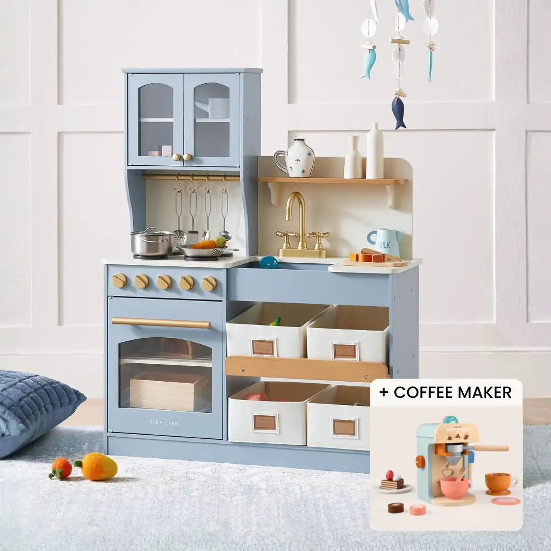 The Tiny Land® Serenity Wooden Kitchen & Coffee Maker playset features a light blue kitchen with cabinets, stove, sink, and storage bins. An inset highlights the coffee maker with cups and accessories for imaginative pretend play fun.