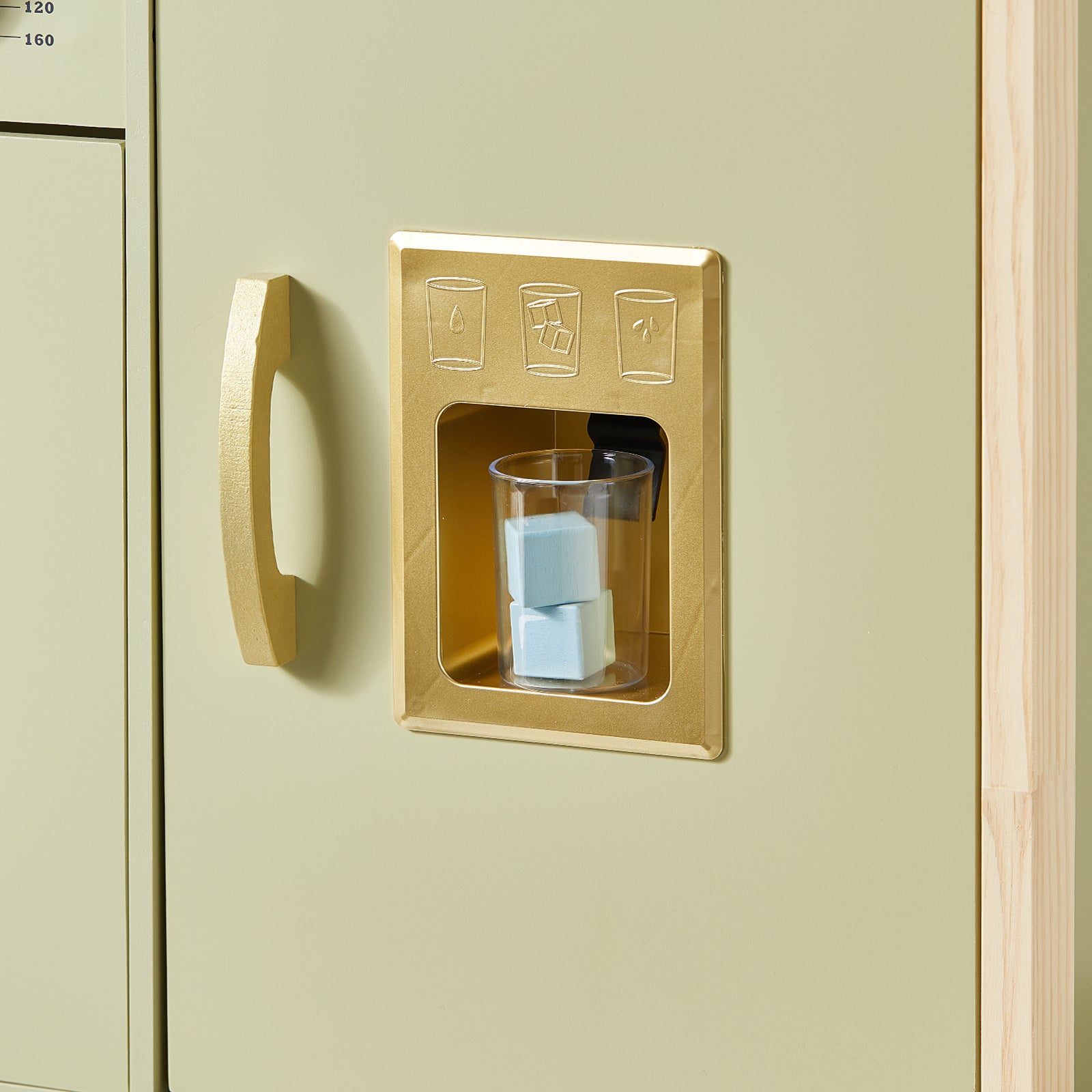 A clear cup with blue ice cubes sits in a gold dispenser on the light green cabinet of the Tiny Land® PopJoy Play Kitchen - Pink / Green, perfectly designed for pretend play, with icons above for water, ice, and crushed ice.|Sage
