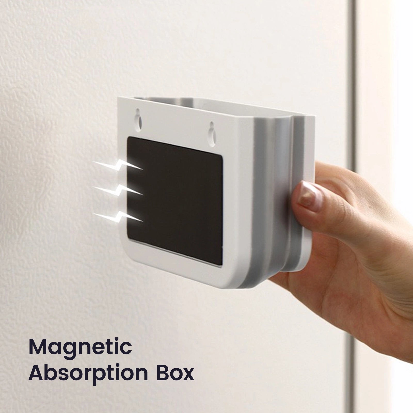 A hand attaches the Tiny Land® Magnitales Easel Art Kit by Tiny Land—a small, rectangular magnetic box with a black front panel—to a metal surface, ideal for organizing art supplies. Text below reads: Magnetic Absorption Box.