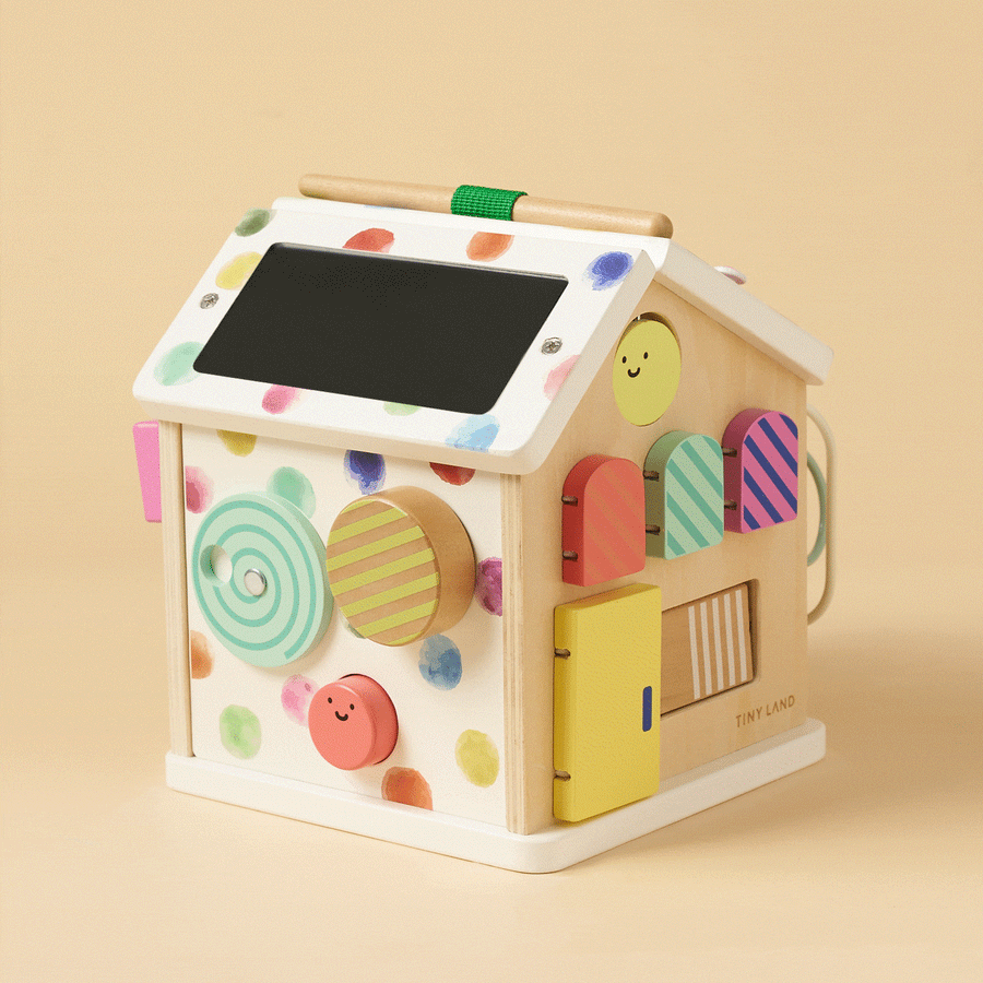 The Tiny Land Rainbow Baby Walker & Activity Cube Developmental Playset is a house-shaped, colorful toy with shapes, doors, knobs, smiley faces, polka dots, a striped roof, and interactive sides for fine motor skill development.