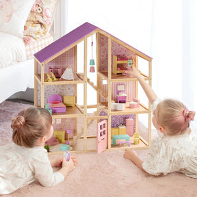 Two young children play with the Tiny Land® Sweetwood Unicorn Dollhouse, complete with pastel-colored rooms and Tiny Land wooden poseable dolls, on a pink rug in a bright bedroom.