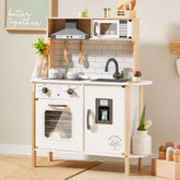 The Tiny Land® Interactive Play Kitchen with Sounds & Cookware features a stove, oven, sink, microwave, utensils, and toy food. “Better together” is written above, with charming plant and flower decorations from Tiny Land.