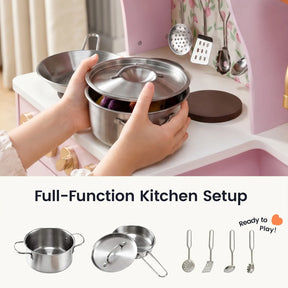 A pair of hands places a metal pot with a lid onto the Tiny Land® Wooden Play Kitchen with Storage for Creative Toddlers, surrounded by an assortment of pretend cookware and miniature utensils—a delightful setup from Tiny Land, ideal for sparking imaginative play.|Sakura Pink