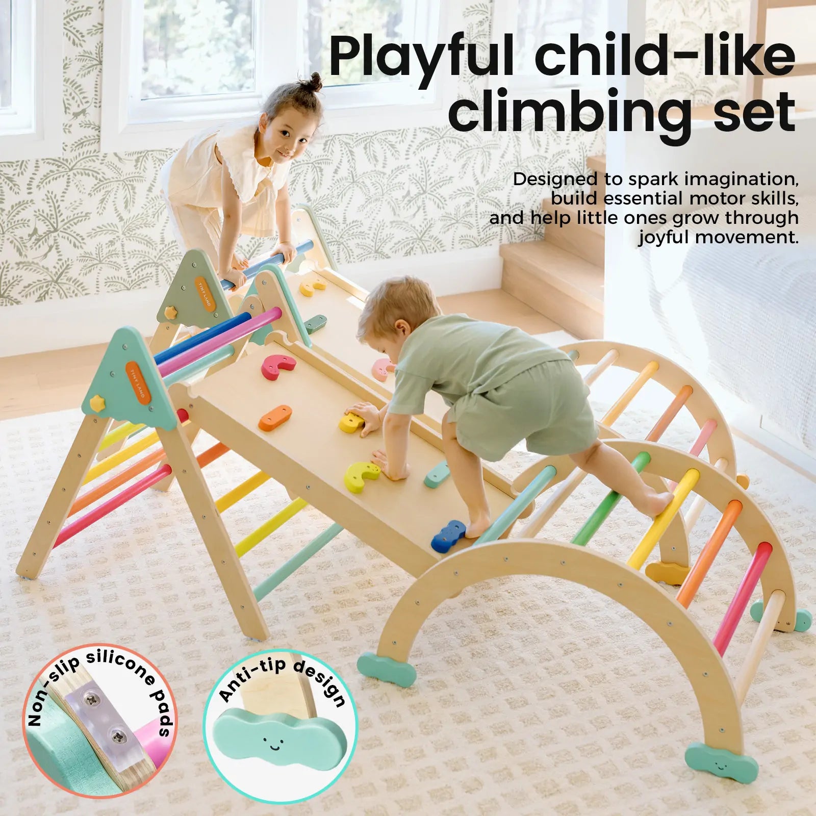 Two young children play indoors on the Tiny Land® 7-in-1 Rainbow Pikler Triangle Set by Tiny Land. This colorful set includes arches, ladders, and a reversible ramp, plus non-slip silicone pads and an anti-tip design in a sunlit, cozy room.