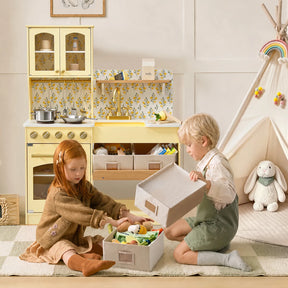 Two young children sit on a rug in a playroom, organizing toys in boxes. In the background, a Tiny Land® Wooden Play Kitchen with Storage for Creative Toddlers, a teepee, and a stuffed bunny from Tiny Land create a cozy and playful atmosphere.|Pale Yellow
