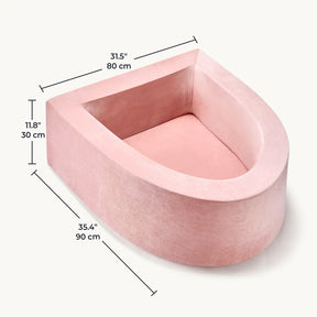 The Tiny Land® PlayNest Ball Pit is a pink, plush, U-shaped pet bed with high back and lower front opening, measuring 31.5" x 35.4" x 11.8". Inspired by the brand’s original design—ocean balls not included.|pink