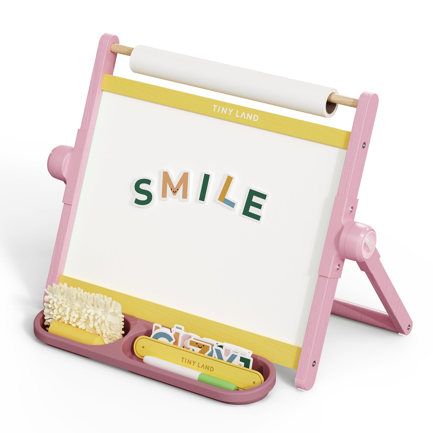 The Tiny Land® Double-Sided Magnetic Tabletop Easel - Pink by Tiny Land is a kids' easel with a whiteboard, colorful magnetic letters spelling “SMILE,” storage trays for art supplies, and a paper roll on top.