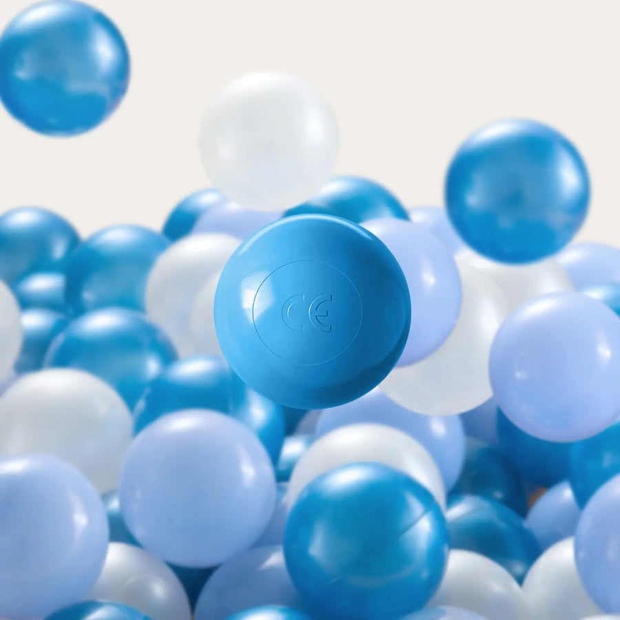 A pile of Tiny Land® Ocean Ball - 200 pcs with Varied Colors by Tiny Land in blue and white shades, featuring a prominent light blue ball. These non-toxic, smooth, shiny play balls are set against a plain, light-colored background.|Blue