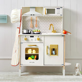 The Tiny Land® PopJoy Play Kitchen by Tiny Land includes a chef hat, oven, stove, sink, utensils, toy food, microwave, and faucet. Set against a light wall with a toy rabbit on the right floor.