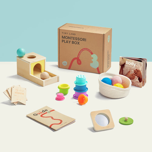 The Tiny Land® Montessori Toys for Newborns (7–9 Months) set by Tiny Land features an Object Permanence Box, stacking cups, sensory and soft balls in a fabric basket, a book, cards, and colorful sensory items on a white surface with a light blue background.