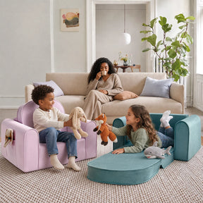 Two children play with stuffed animals while sitting on colorful Tiny Land® GentleSnug Kids Sofa Chairs, as a woman relaxes on a beige couch in the background, watching them. The bright and cozy room is decorated with modern accents and a large plant.|Blue