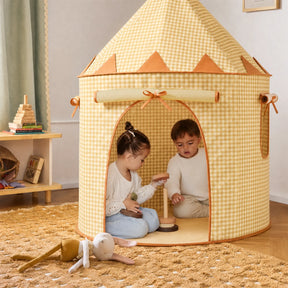 Two young children play with wooden toys inside the Tiny Land® Kids Tent – Indoor Tent for Toddlers by Tiny Land INC. A soft doll and toy blocks are on the carpeted floor, surrounded by warm decor and a wooden shelf holding more toys in the background.