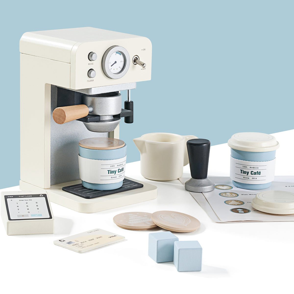 The Tiny Land® Play Kitchen Accessories – Children’s Coffee Maker is a wooden café play set for kids featuring a white and silver toy barista set, coffee cups, milk jug, tamper, menu, credit card, wooden cubes, and more fun accessories.