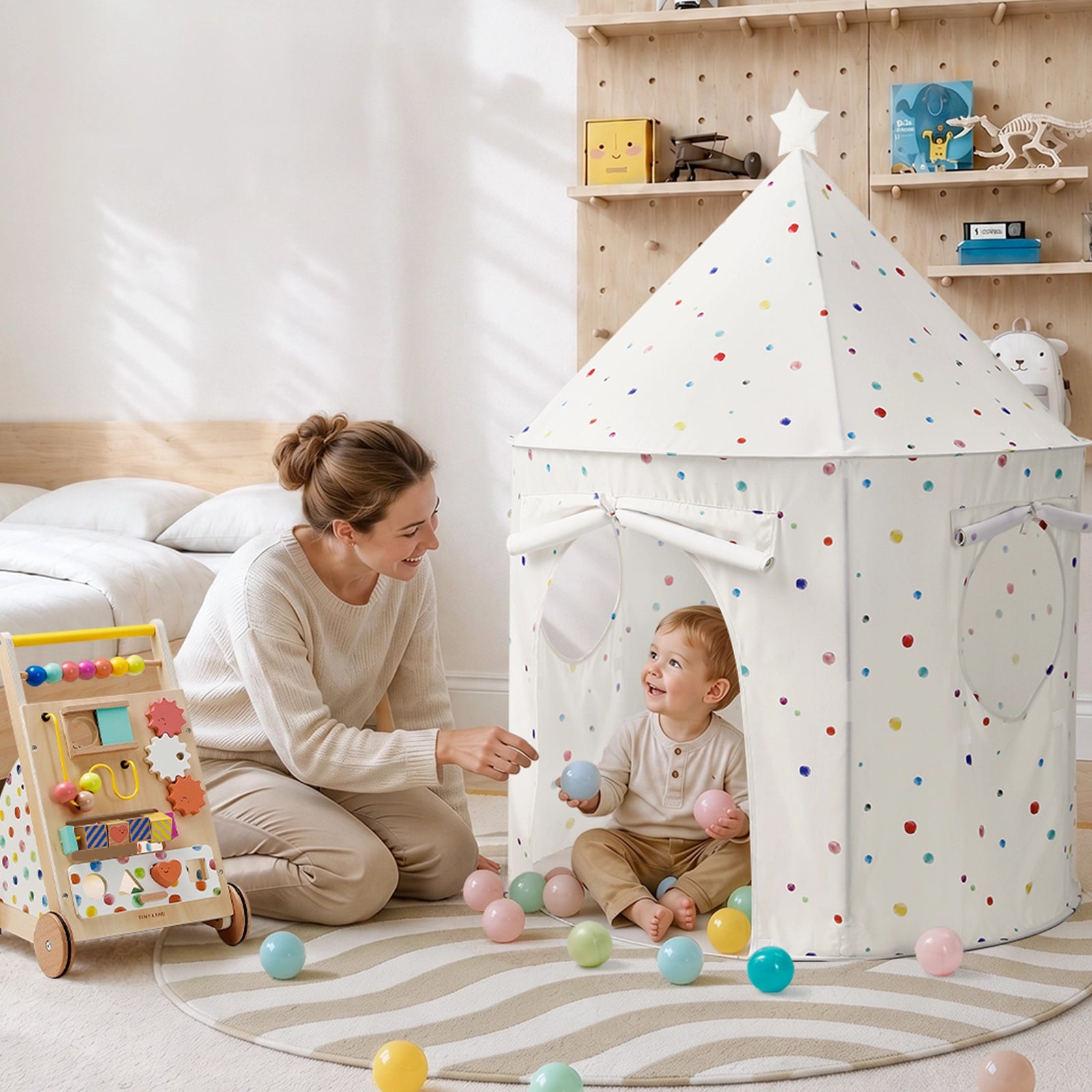 A woman kneels beside a child playing inside a white Tiny Land® Kids Tent – Indoor Tent for Toddlers decorated with colorful dots and filled with plastic balls.|Colorful Dots
