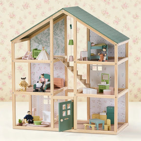 The Tiny Land® Sweetwood Evergreen Dollhouse & Wooden Dollhouse Dolls by Tiny Land INC is a wooden dollhouse with six rooms, miniature furniture, an open front, green roof, floral wallpaper, and four wooden dolls posed in various rooms.