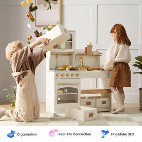 Two children play with the Tiny Land® Wooden Play Kitchen with Storage for Creative Toddlers; one pours toy vegetables from a storage bin while the other stands nearby. Pretend cookware, bins, and play food are scattered on the floor. Icons below highlight organization, real-life connection, and fine motor skill development.|cream